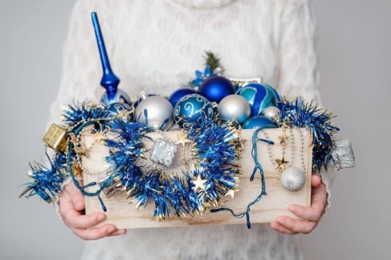 box of blue decor in hands